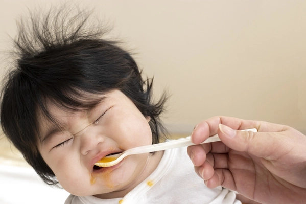 無理に食べさせられて泣く赤ちゃん