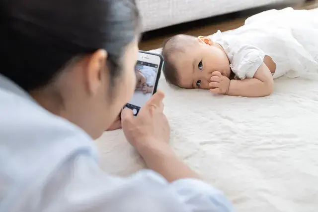 赤ちゃんの写真をとるママ