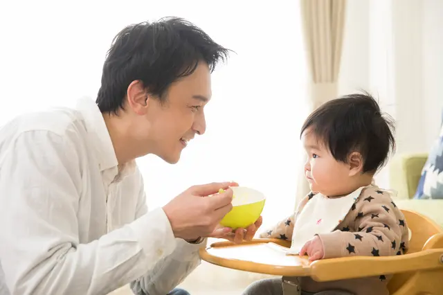 離乳食を食べさせるパパ