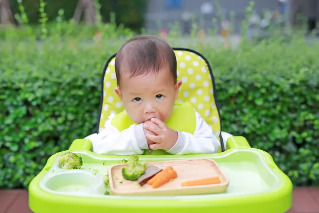つかみ食べをしているテーブルを汚してしまう赤ちゃん