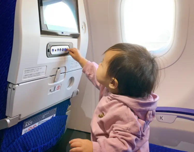 機内でボタンを押す子ども