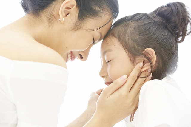肌の調子を確かめる母親