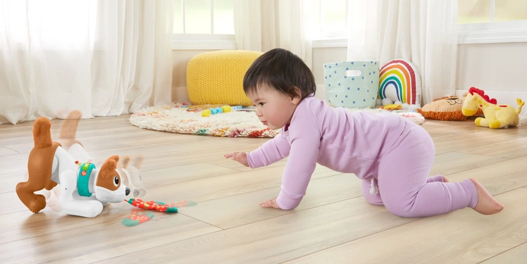 はいはいをしてバイリンガル パピーで遊ぶ赤ちゃん