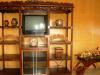 Living room with tv cabinet made from antique narra wood. Decors are Oriental, including the wooden wheel barrow filled with flowers.