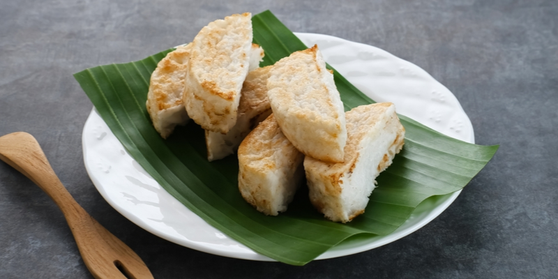 Kue Pancong yang baru matang, disajikan dengan taburan gula pasir yang manis dan gurih, siap dinikmati