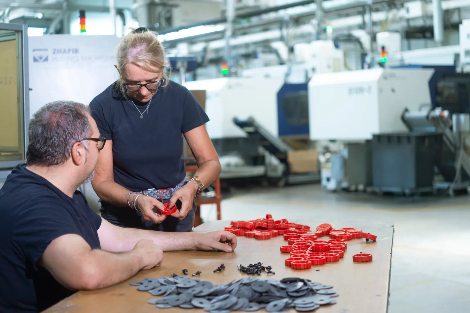 Foto di due tecnici mentre assemblano dei componenti in plastica