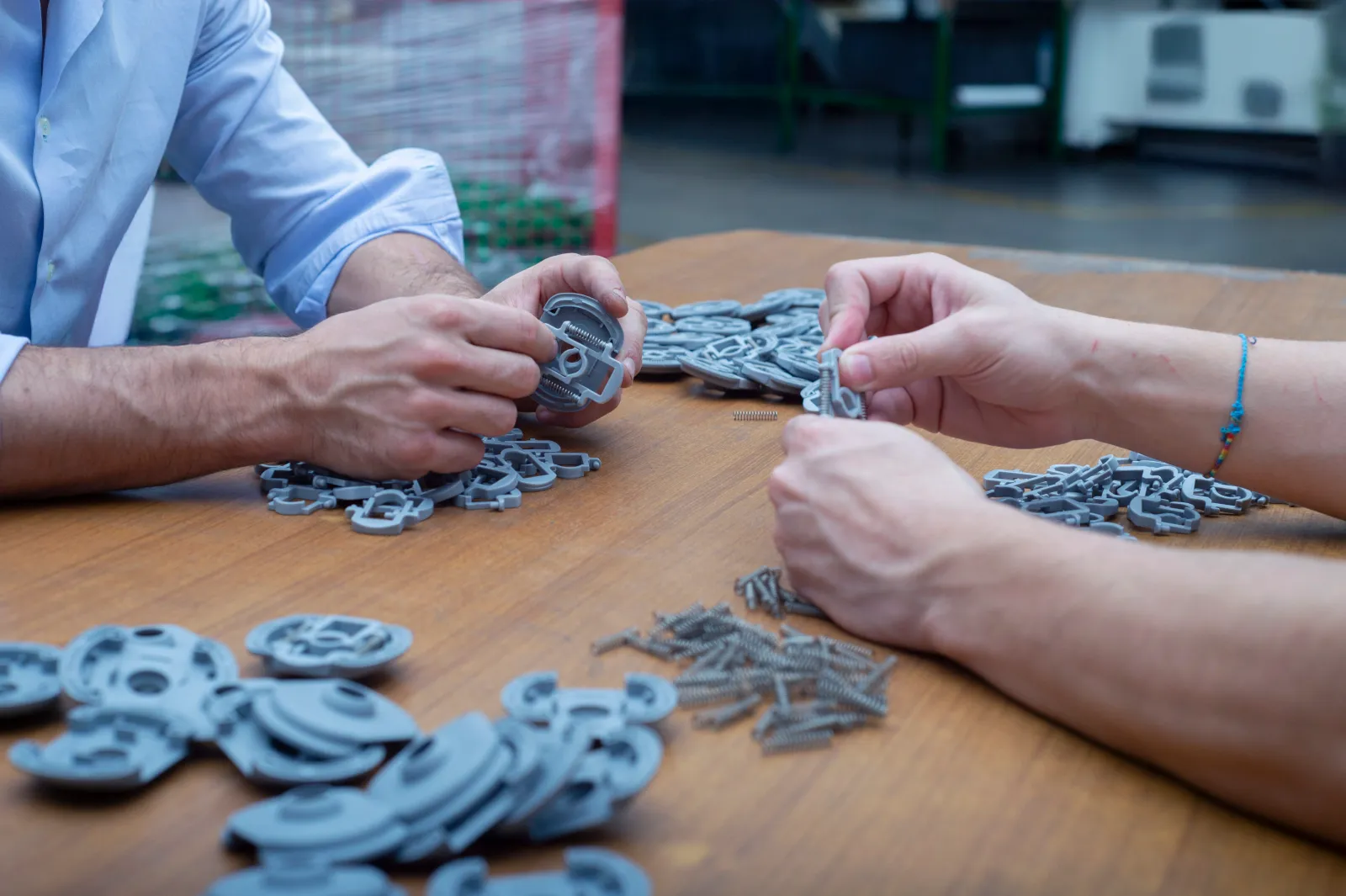 Foto che ritrae mani che assemblano pezzi in plastica
