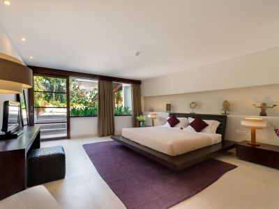 Luxurious modern bedroom with platform bed, tropical garden view, and floor-to-ceiling windows.