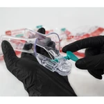 espéculo vaginal descartável transparente segurando na mão com luva preta