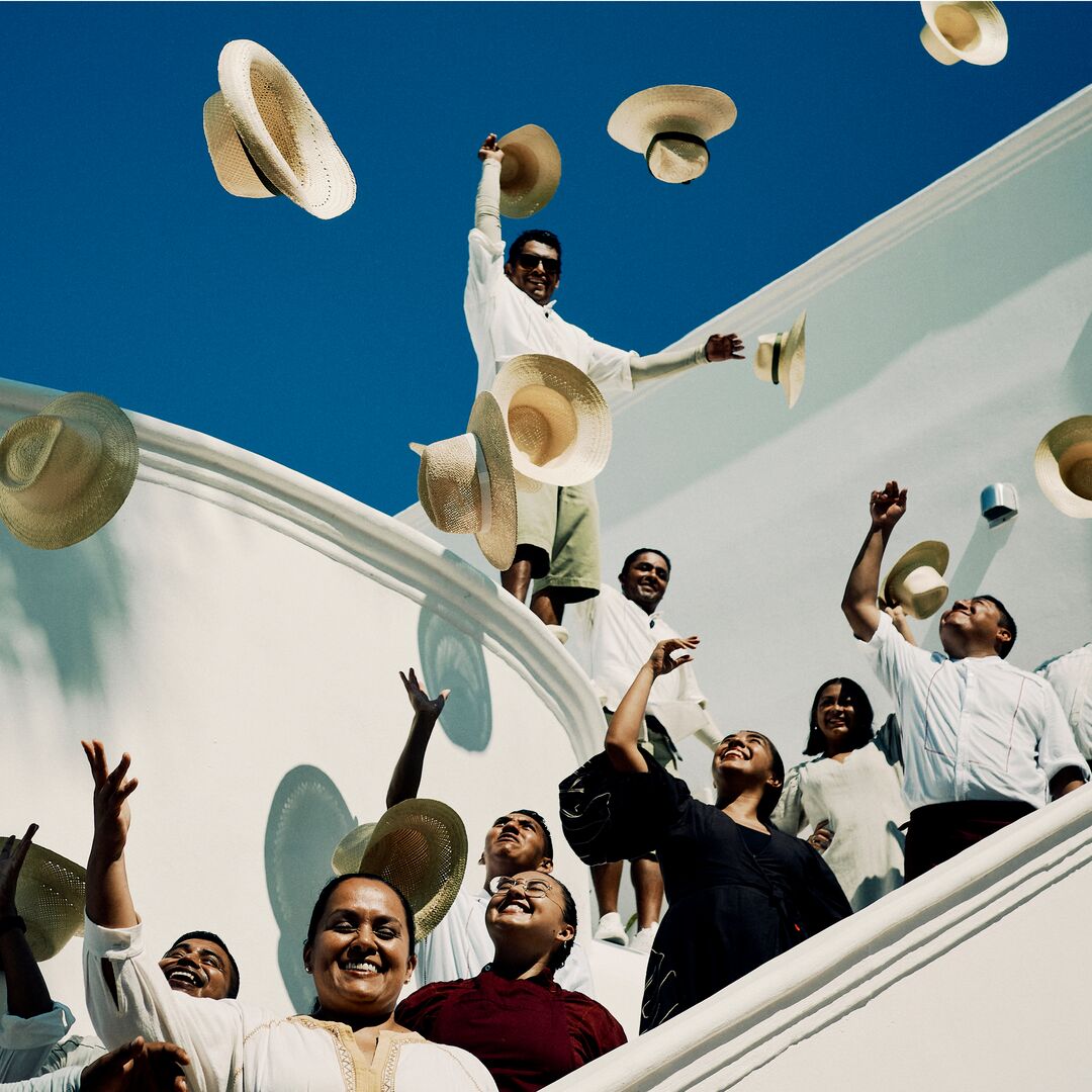 Employees outside throwing their hats in the air