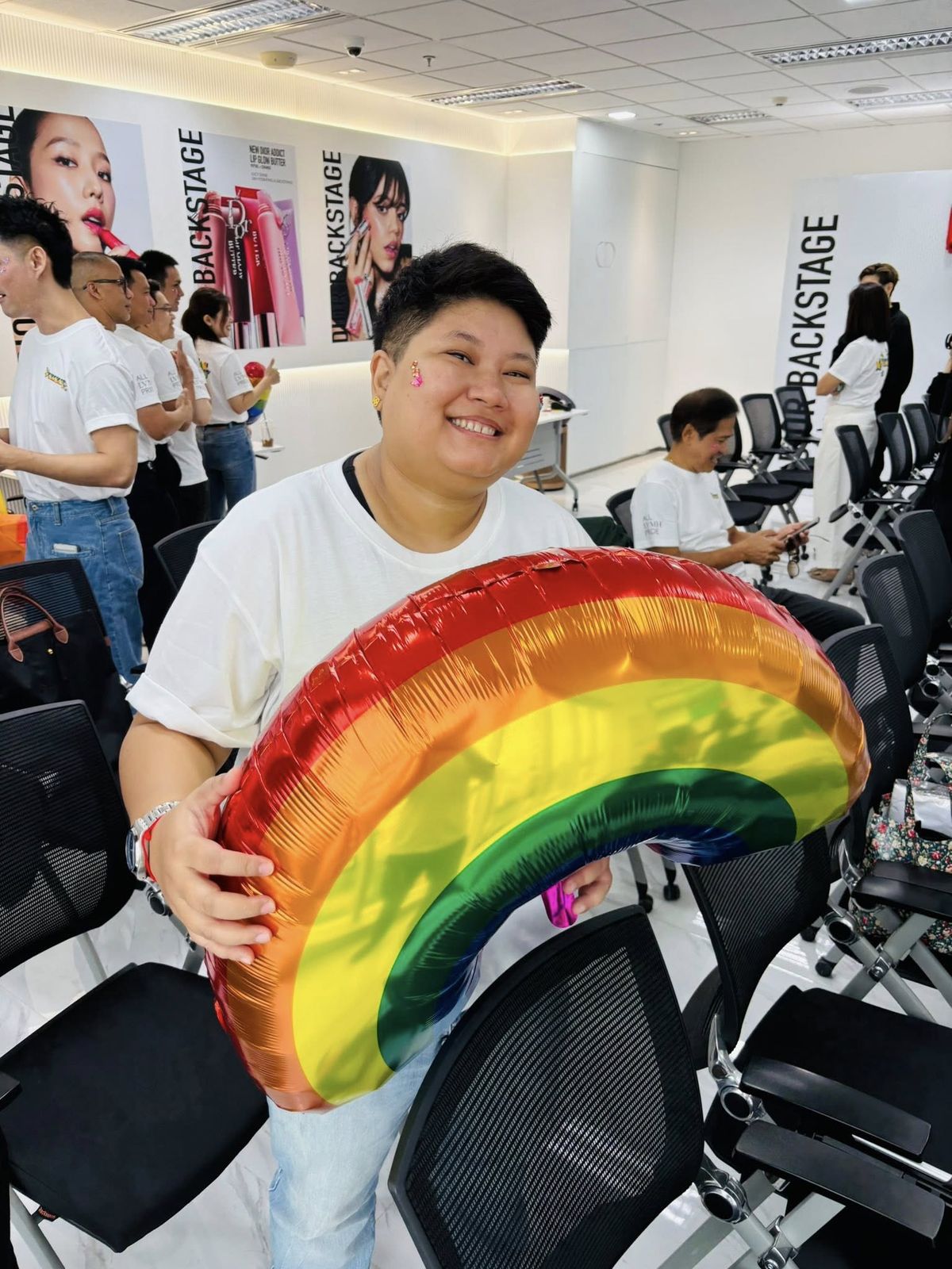 Employee holding rainbow balloon
