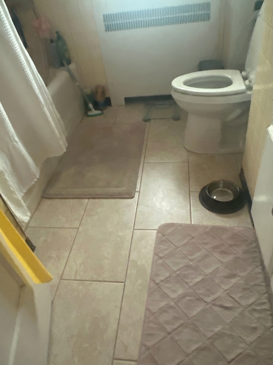 Bathroom floor renovation with herringbone tile pattern