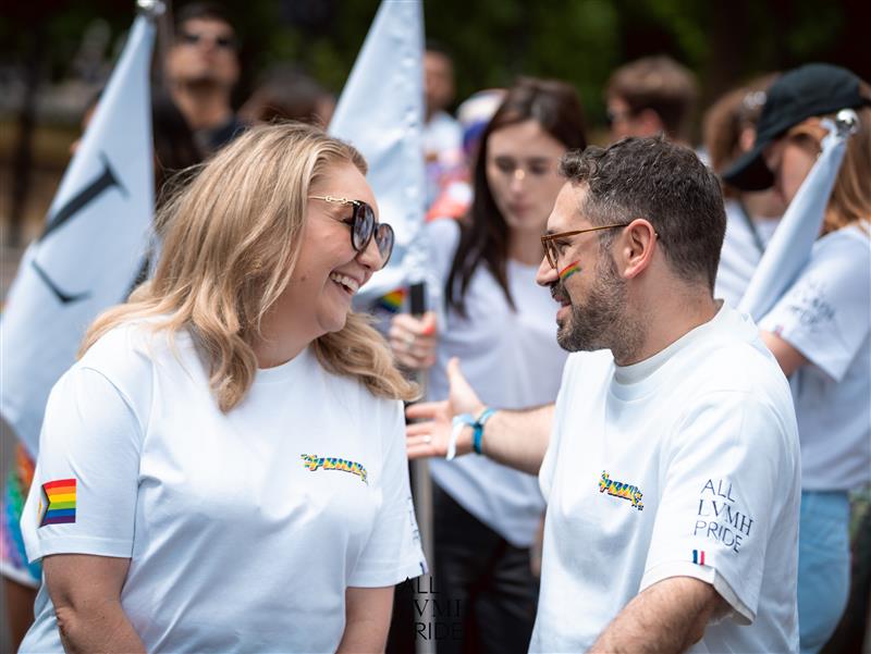 employees talking and smiling with each other at pride parade