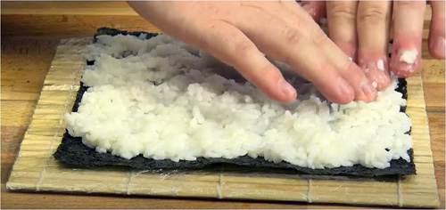 Distribuire il riso sul foglio di alga nori