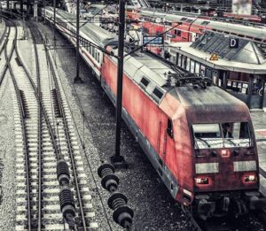 Foto: In einem großen Bahnhof sind stehende Fernzüge und Schienen zu sehen.