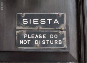 Foto: Ein verwittertes Emailleschild, auf dem steht „Siesta - please do not disturb“ zu deutsch: Mittagsruhe - bitte nicht stören.