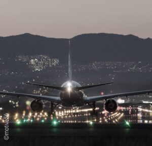 Foto: Ein Flugzeug auf einer nächtlich erleuchteten Landebahn.