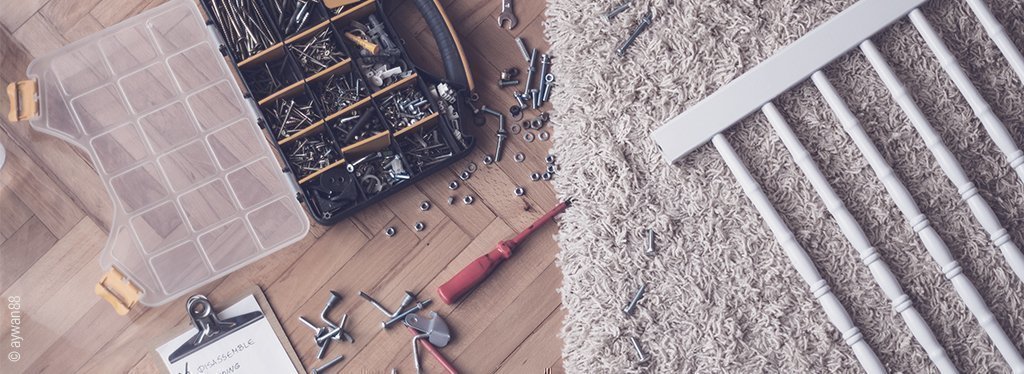 Foto: Aufbau von einem Beistellbett, auf dem Boden liegen Werkzeug und Schrauben