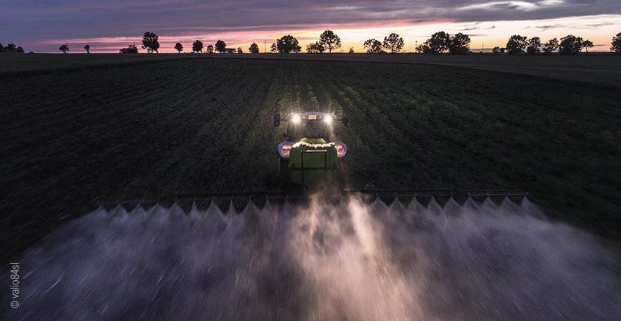 Foto: Ein Traktor sprüht Pestizide auf einem Feld.