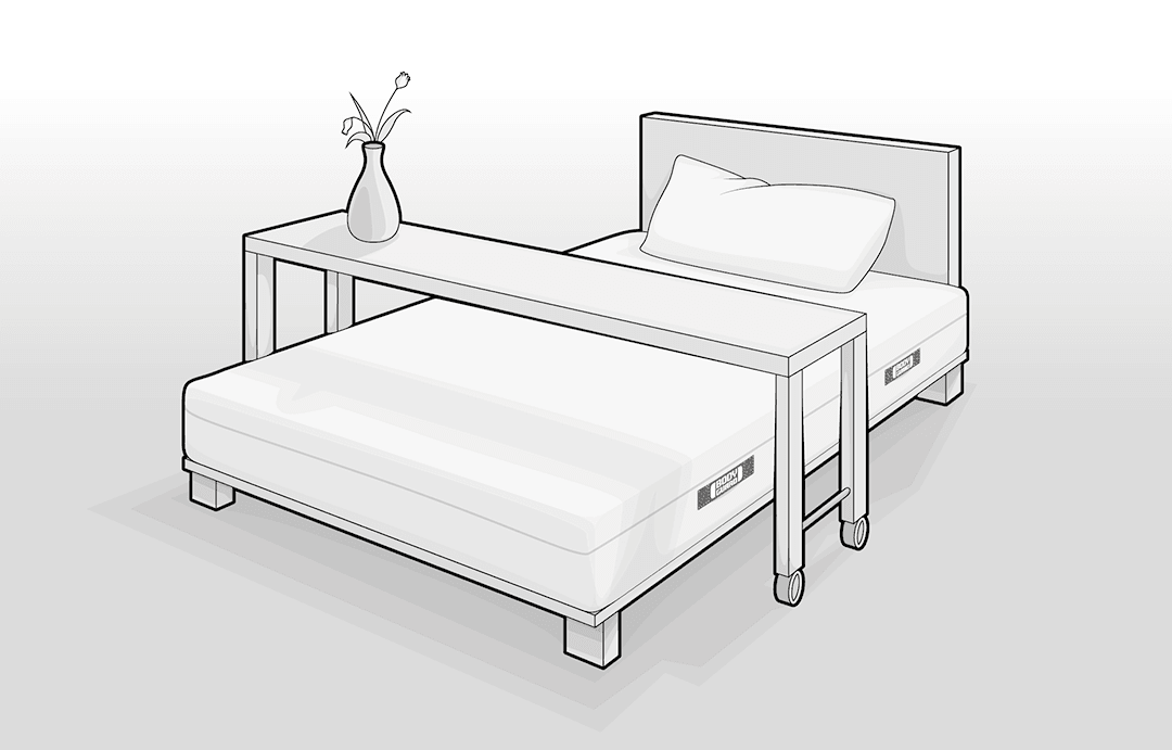 Illustration: ein Betttisch, der übers gesamte Bett geht. Die Tischbeine stehen auf Rollen.