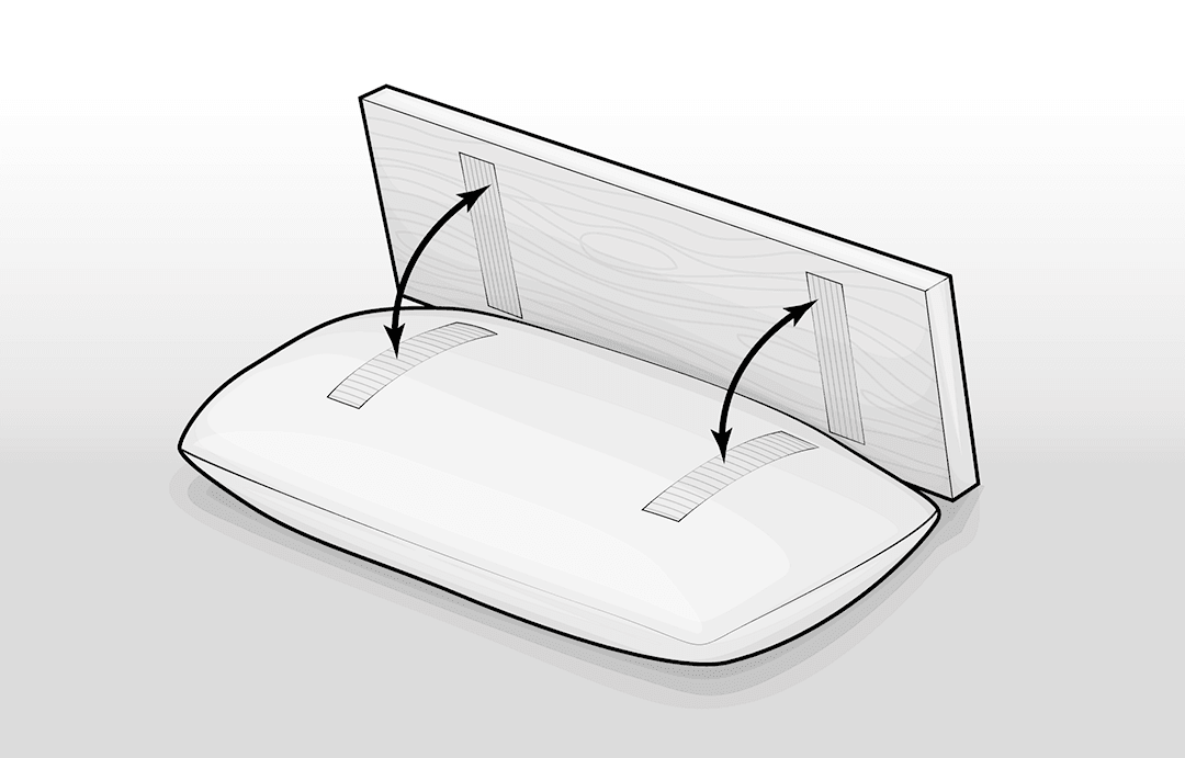  Illustration Anleitung Kissen-Betttablett: Ein Kissen mit Klettstreifen auf der Oberseite, dahinter steht ein Holzbrett, an dessen Unterseite ebenfalls Klebestreifen sind. Zwei Pfeile dazwischen signalisieren das Zusammenführen zum Betttablett.