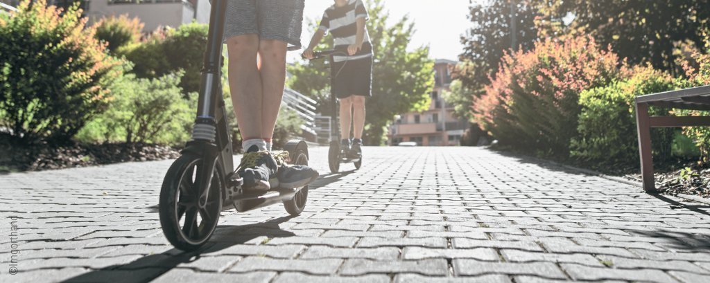 Foto: Zwei Jungs fahren auf Scootern.