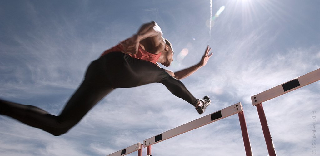 Foto: Ein Sportler springt über ein Hindernis.