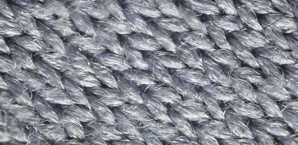 Foto: Makroaufnahme eines Stoffes aus Microfaser; die einzelnen Fäden sind gut erkennbar.