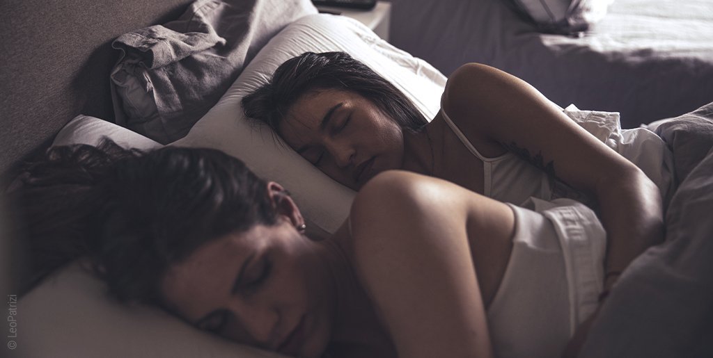 Foto: Ein Pärchen schläft nebeneinander in einem Bett.