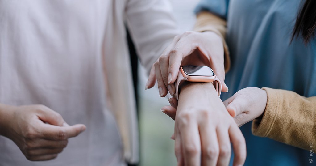 Foto: Eine Person legt einer anderen Person eine Smartwatch, die die Blutsauerstoffsättigung im Schlaf messen kann, an.