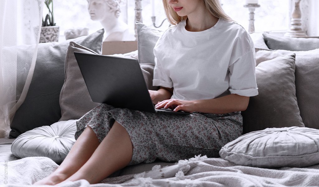 Foto: Eine Person mit leicht angewinkelten Beinen hat einen Laptop auf dem Schoß.