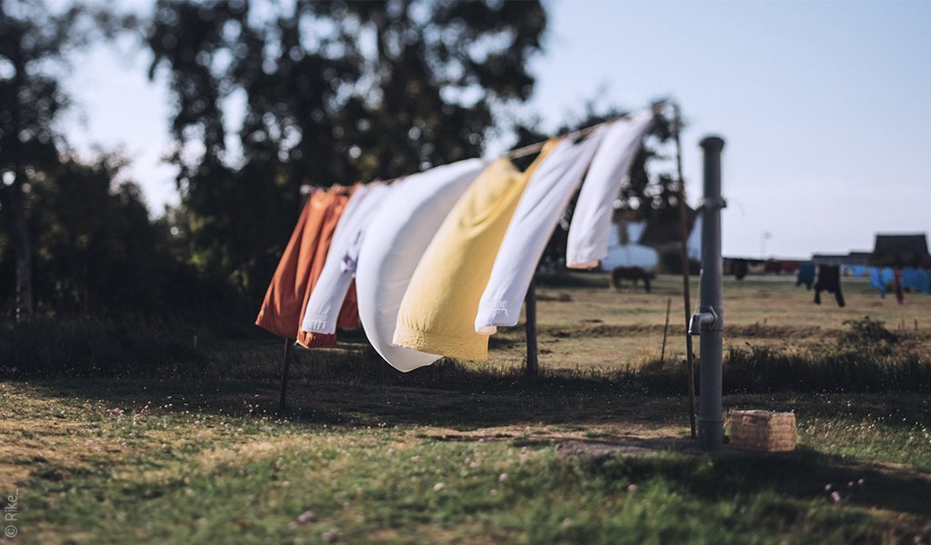 Foto: Eine Wäscheleine auf einem Feld an der Kinderbettwäsche 100x135 hängt.