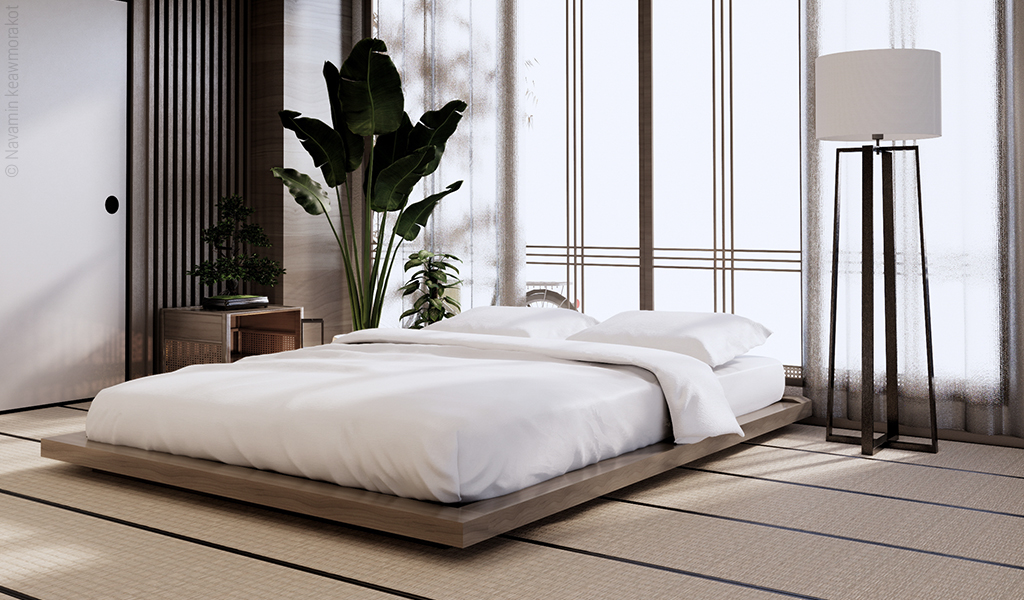 Foto: Eine breite Doppelbettmatratze liegt auf einem sehr niedrigen Bettgestell, welches dem Auf-dem-Boden-Schlafen sehr nahekommt.
