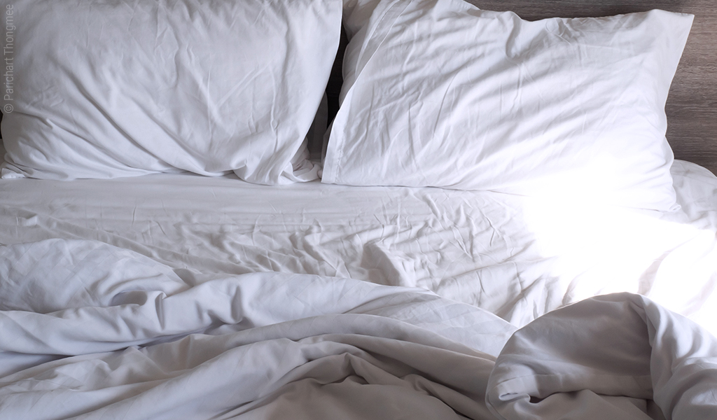 Foto: Frontansicht auf ein ungemachtes Bett