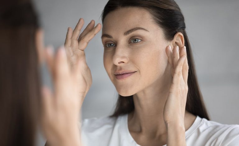 Mulher fazendo massagem facial para revitalizar a pele.