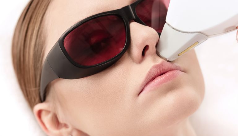 Mulher fazendo tratamento com laser no rosto.
