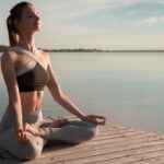 Mulher meditando a beira do mar