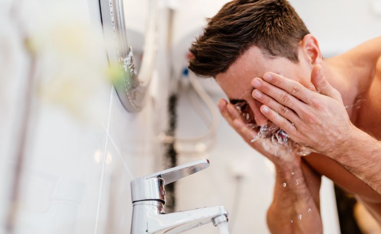 homem lavando o rosto