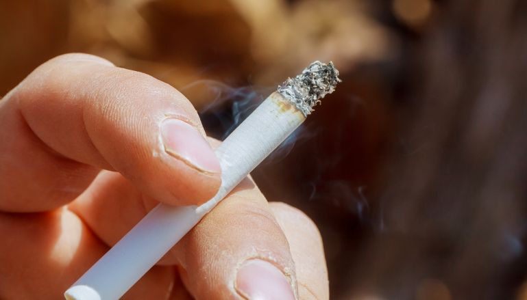 Cigarro na mão de homem