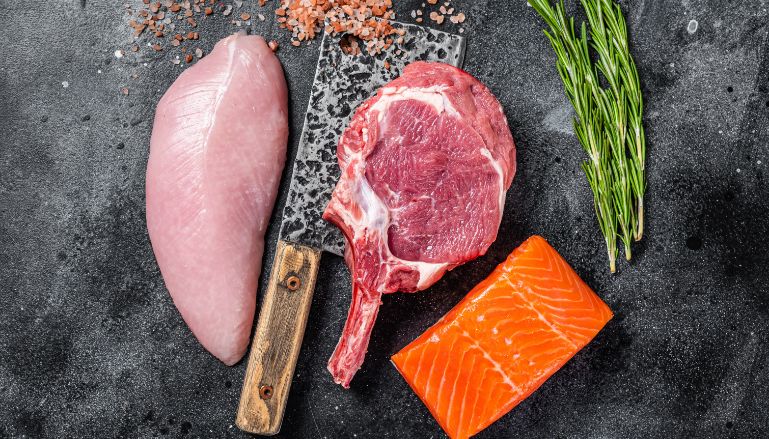 Frango, salmão e alecrim em cima de tábua
