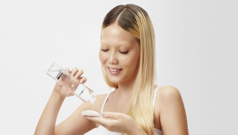Menina aplicando água micelar da Beyoung em algodão.
