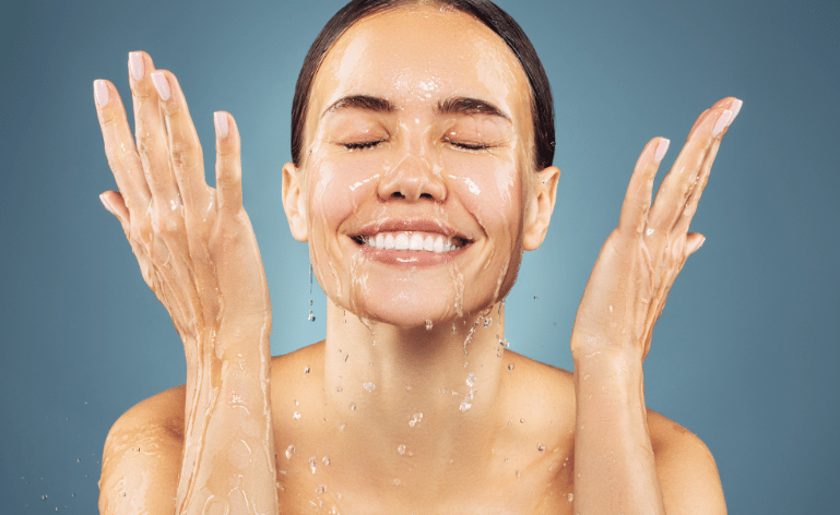 Mulher sorridente lavando o rosto