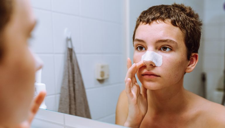 Garoto usando produto de skincare dermatologicamente testado.