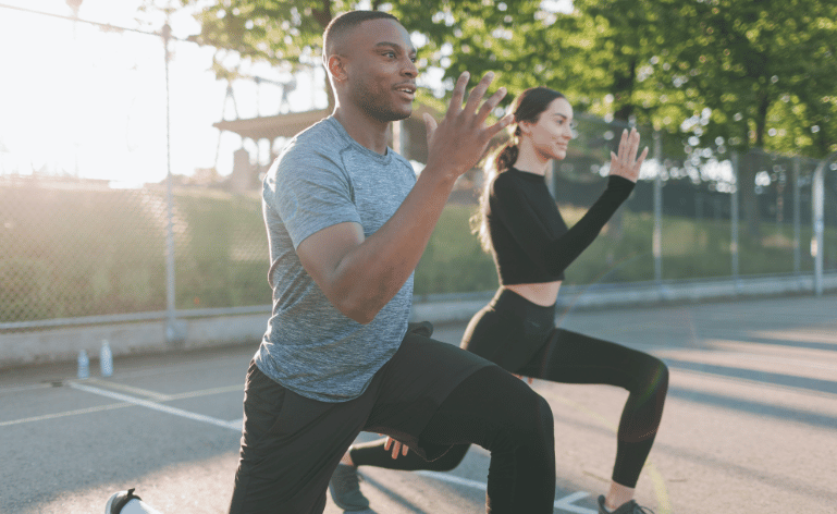 Duas pessoas praticando exercícios ao ar livre, remetendo à boas práticas para envelhecer bem.