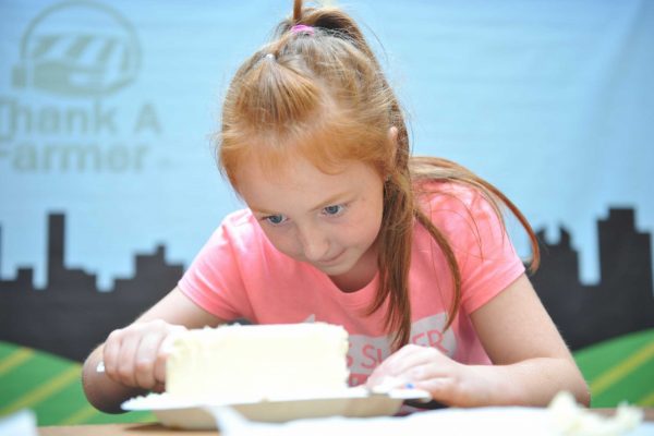 A young Fairgoer partakes in a butter sculpting contest in the Paul R. Knapp Animal Learning Center.