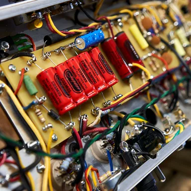 Interior of a Milkman Sound amplifier showing Jupiter capacitors and hand-wired components
