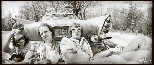 Phish posed against a vintage car