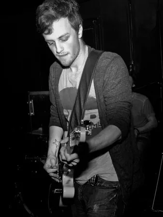 Justin playing guitar at a venue