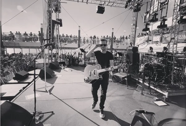 The Key of B Natural — Justin on stage with acoustic guitar