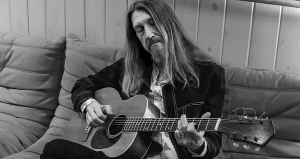 Oliver Wood playing acoustic guitar